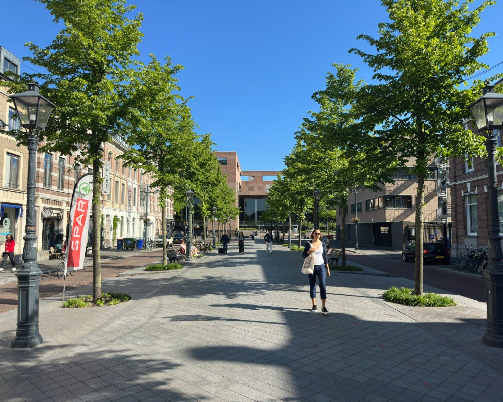 Voorbijganger in een groene Bredase winkelstraat